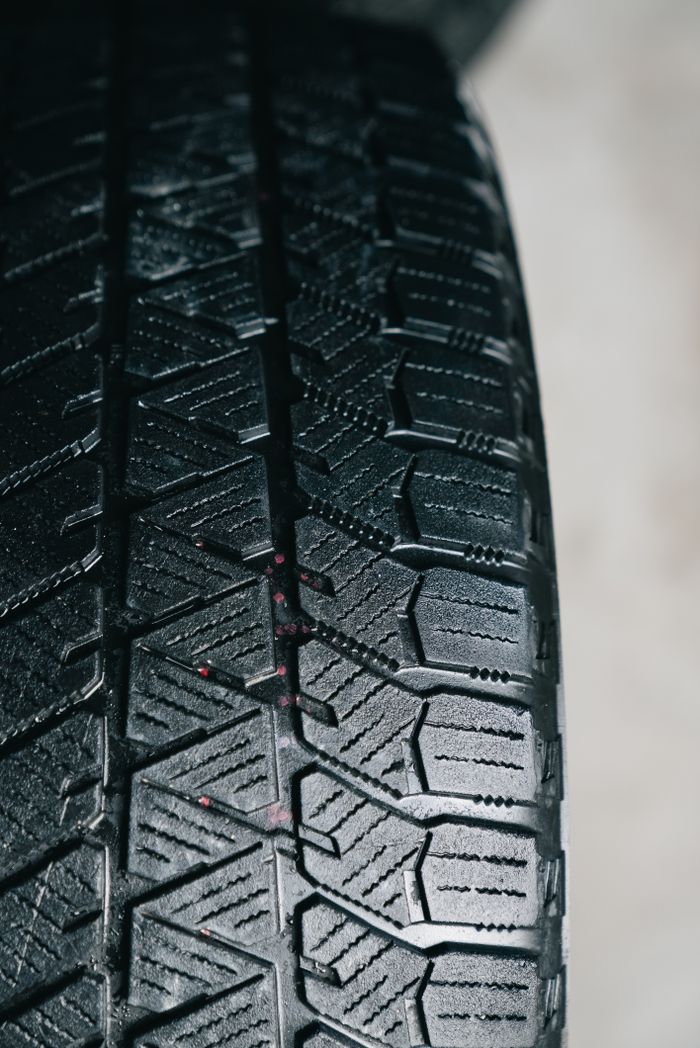 Detailed close-up of a car tire tread showcasing intricate rubber patterns, ideal for automotive themes.